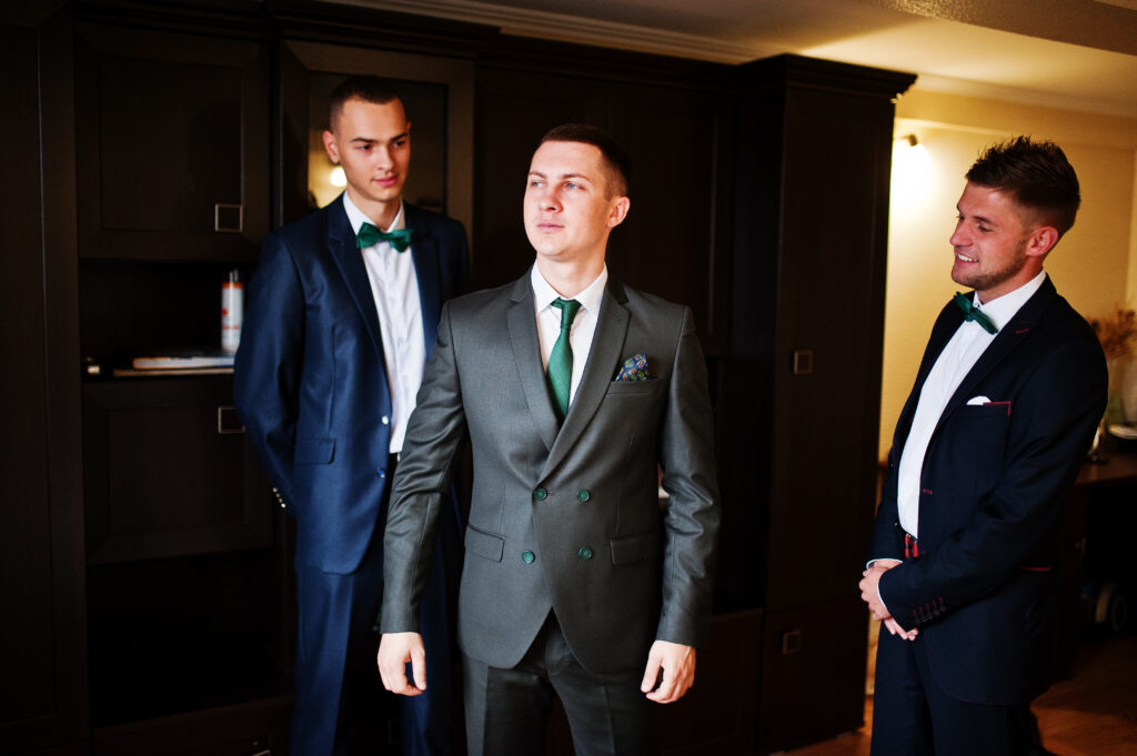 handsome,groom,posing,with,his,groomsmen,in,the,room,before